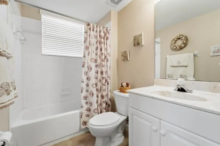 Bathroom with vanity and shower / bath combination with curtain