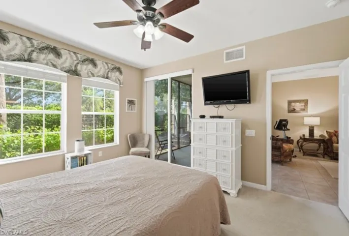 Bedroom featuring access to exterior, carpet flooring, a ceiling fan, and tile patterned floors