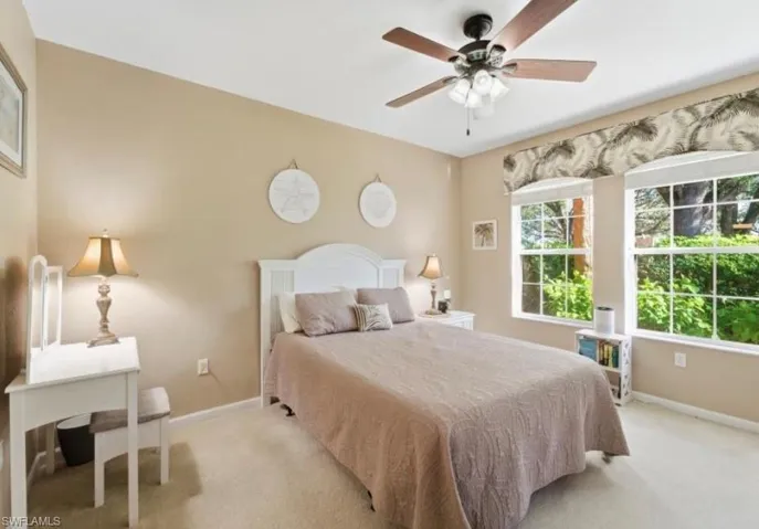 Carpeted bedroom with baseboards and ceiling fan