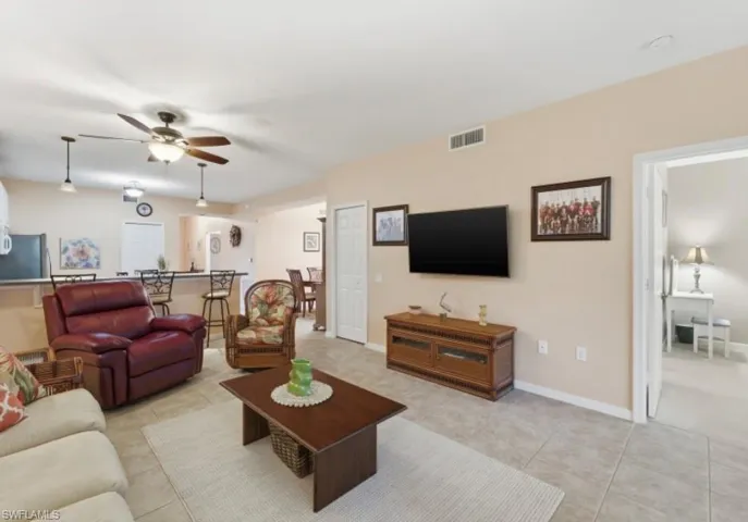 Living area featuring a ceiling fan and light tile patterned floors