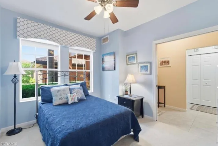 Bedroom with a ceiling fan and light carpet