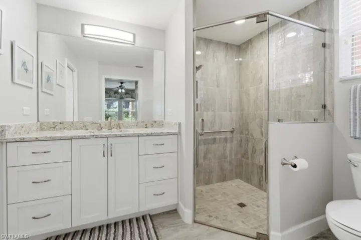 Full bathroom with vanity, a shower stall, and healthy amount of natural light