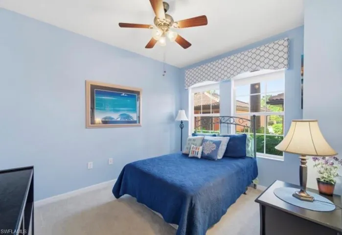 Carpeted bedroom featuring baseboards and a ceiling fan