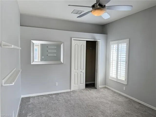 Unfurnished bedroom featuring carpet flooring, a closet, and ceiling fan