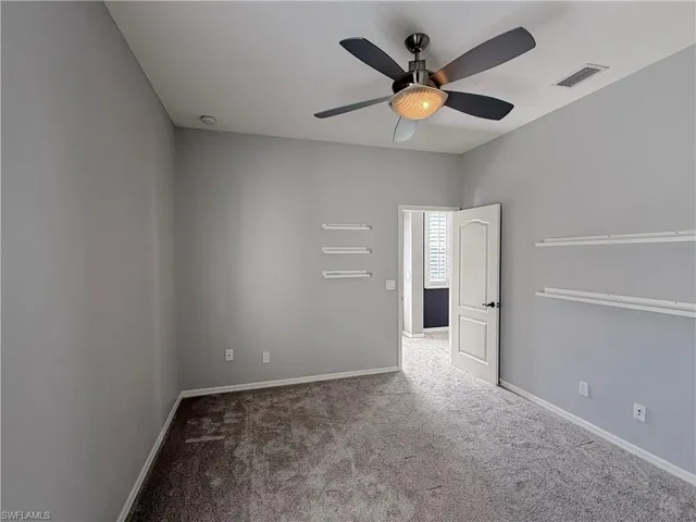 Unfurnished room featuring ceiling fan and carpet floors