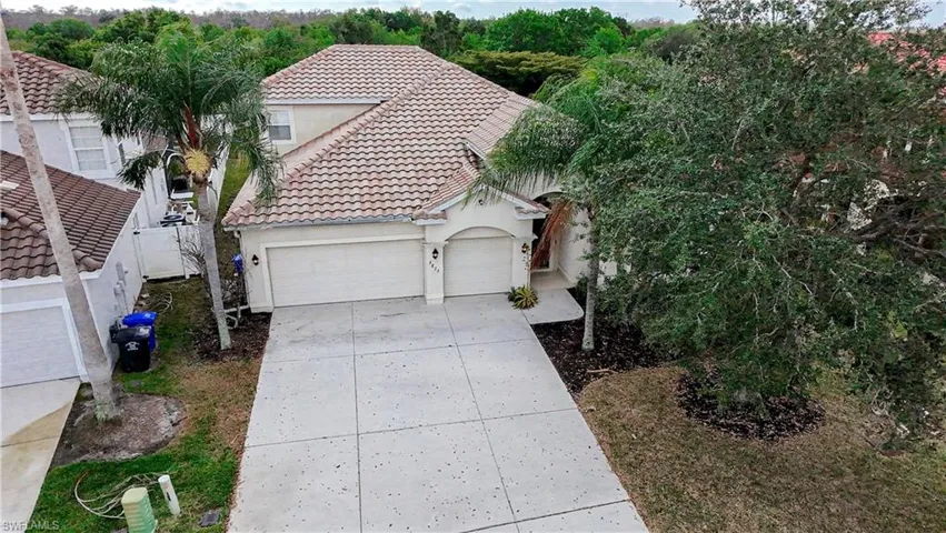 Mediterranean / spanish house with a tiled roof, stucco siding, a garage, and driveway
