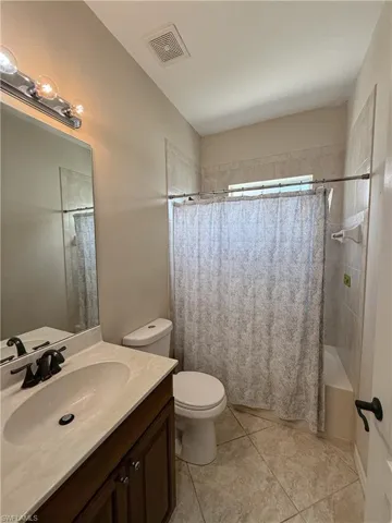 Full bathroom with vanity, shower / tub combo, and light tile patterned floors