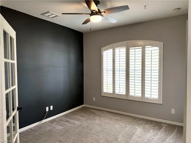 Spare room with a ceiling fan and carpet