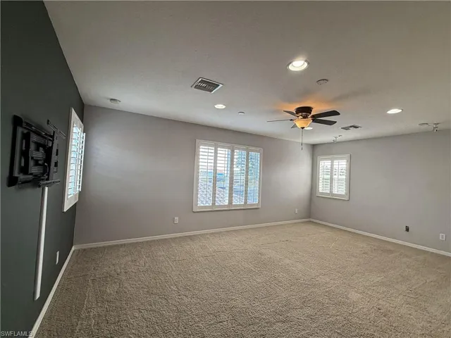 Unfurnished room featuring light colored carpet, ceiling fan, and recessed lighting