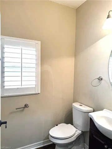 Half bathroom featuring vanity and toilet