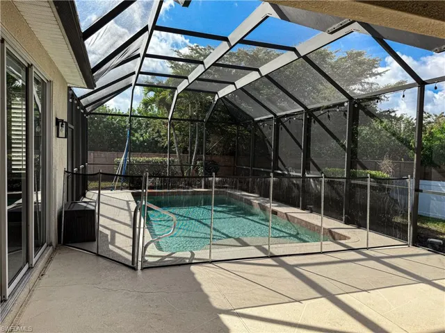View of pool with patio surround, a fenced backyard, a sunroom, and a lanai