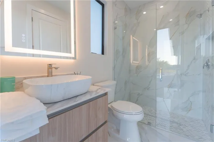 Bathroom featuring vanity, toilet, and walk in shower