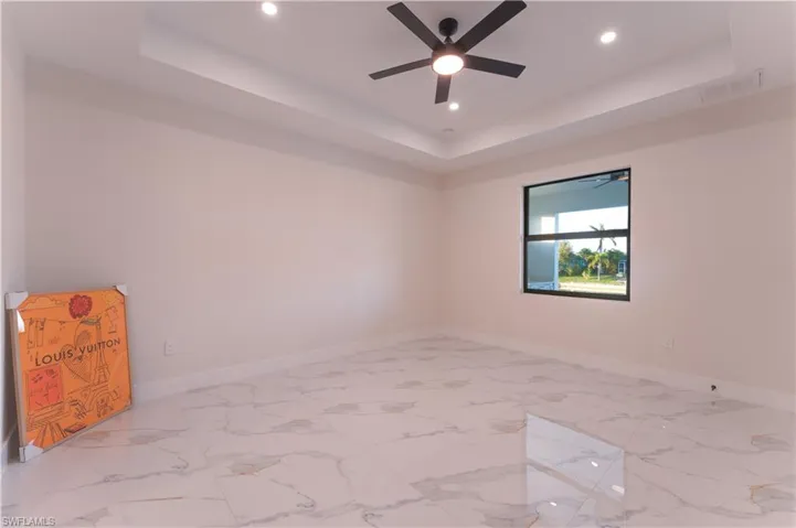 Spare room with a tray ceiling and ceiling fan