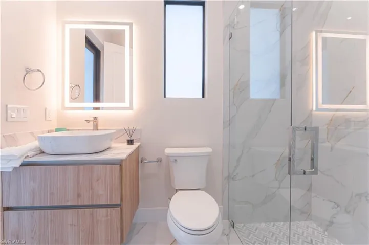 Bathroom featuring vanity, toilet, and a shower with shower door
