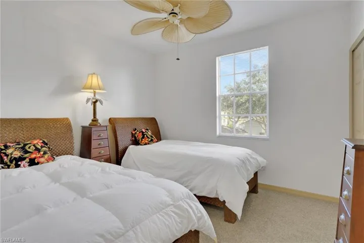 Bedroom with light colored carpet and ceiling fan