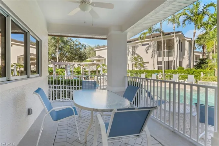 Balcony featuring outdoor dining area, a ceiling fan, and view of pool