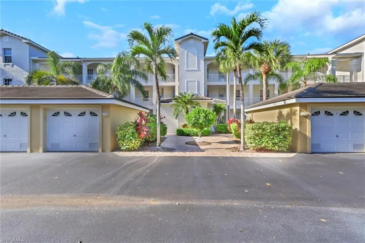 View of front of house featuring stucco siding, community garages, and a tiled roof