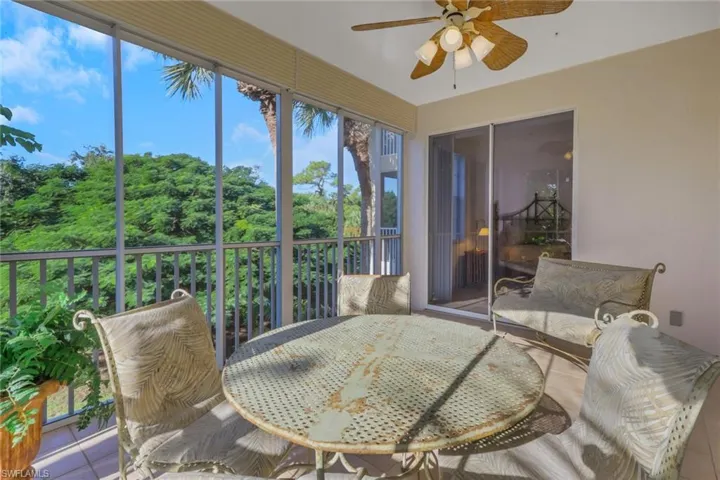 Sunroom featuring ceiling fan, tile patterned floors, and outdoor dining area