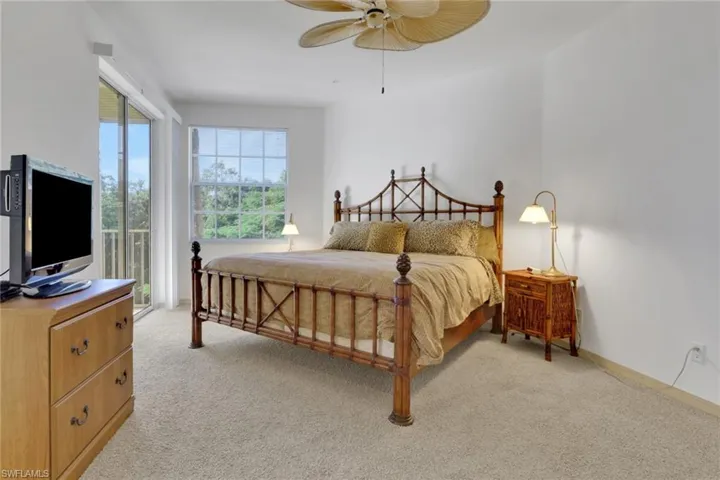 Bedroom featuring light colored carpet, access to outside, and a ceiling fan
