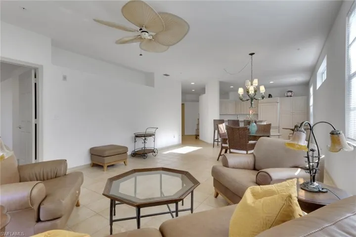 Living room with a chandelier, light tile patterned floors, recessed lighting, and a ceiling fan