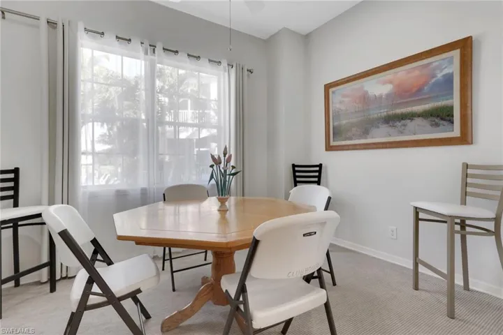 Dining space featuring light colored carpet and ceiling fan
