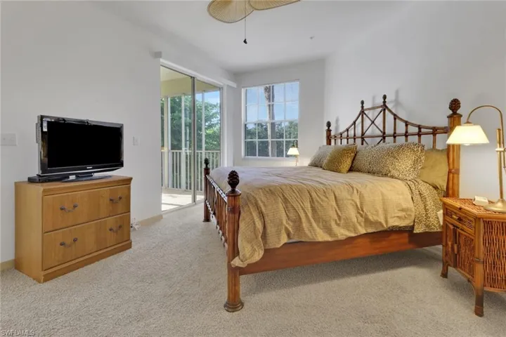Bedroom featuring access to outside, light colored carpet, and ceiling fan