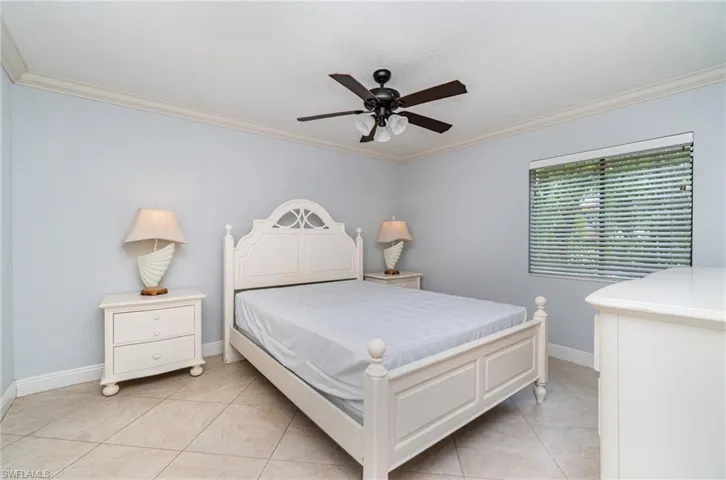 Bedroom featuring crown molding, light tile patterned floors, and ceiling fan
