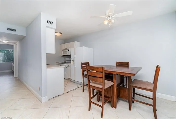 Dining area with light tile patterned floors and ceiling fan