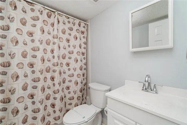 Full bathroom featuring vanity, a shower with curtain, and a textured ceiling