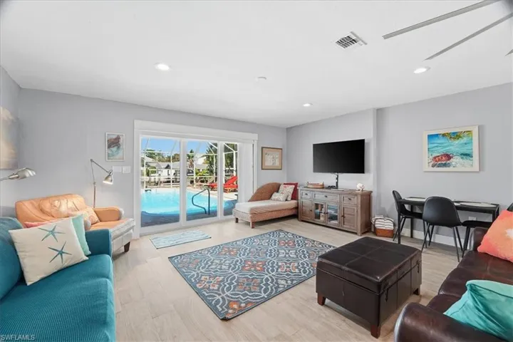 Living area featuring light wood-style flooring, a ceiling fan, and recessed lighting