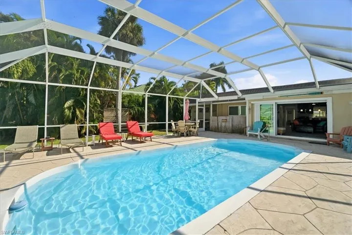 Swimming pool with a patio area, a lanai, and a sunroom