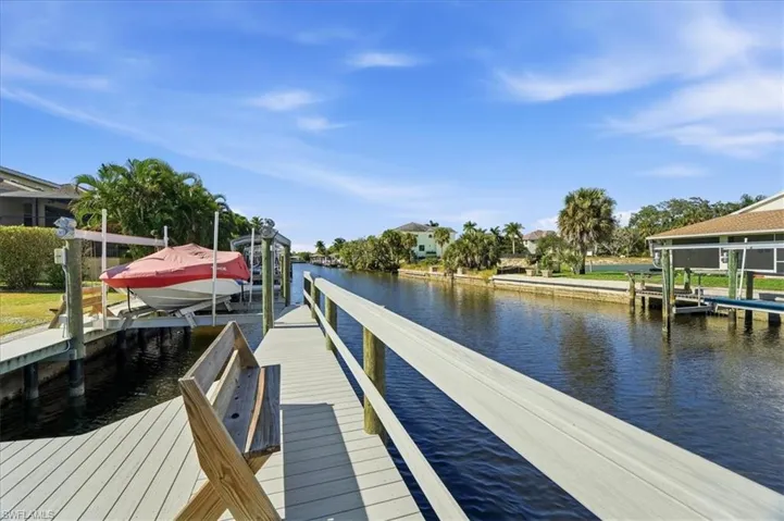 Dock area featuring boat lift and a water view