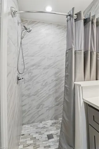 Full bath featuring a shower stall and vanity