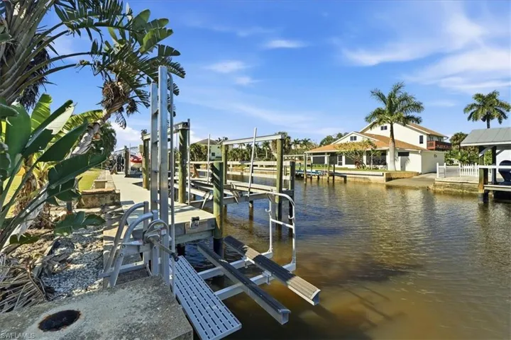 Dock featuring boat lift and a water view