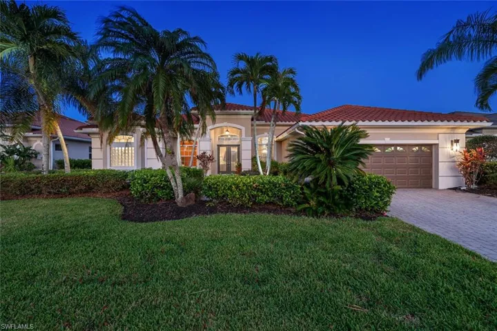Mediterranean / spanish house featuring a front lawn and a garage