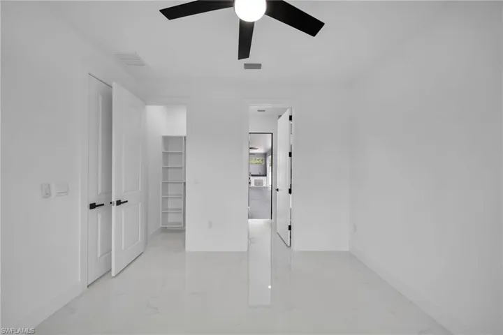 Unfurnished bedroom featuring a closet, light tile patterned floors, and ceiling fan