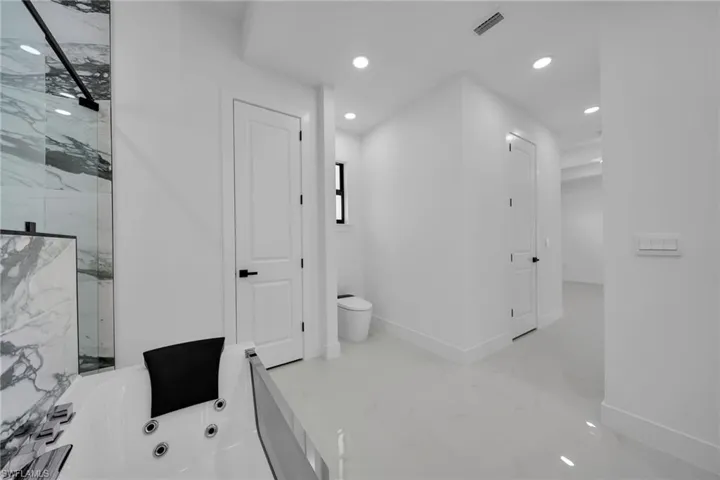 Bathroom with a washtub, tile patterned floors, and toilet