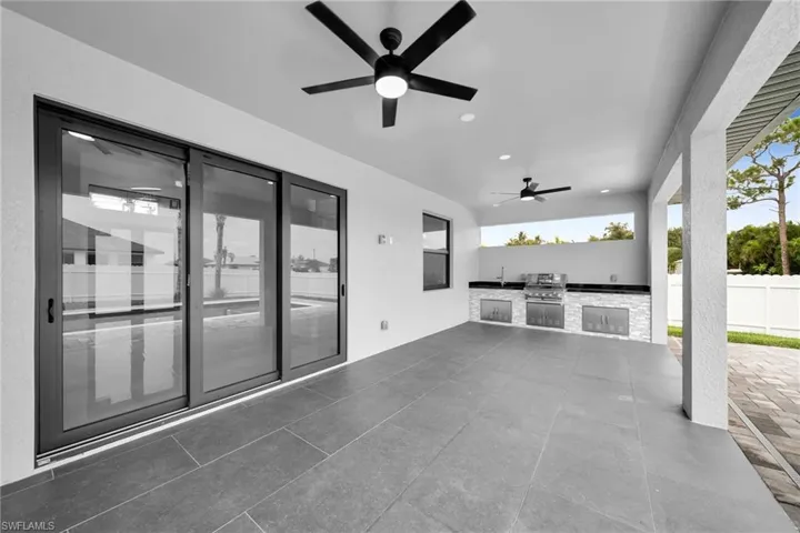View of patio featuring sink, ceiling fan, area for grilling, and a grill
