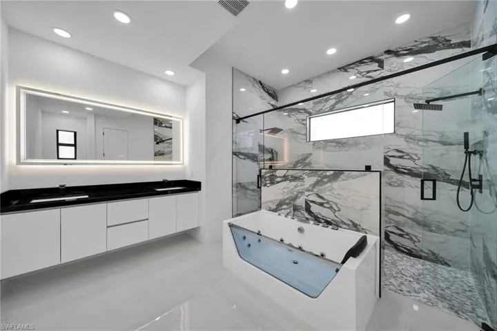 Bathroom with a shower with door, tile patterned flooring, and double vanity