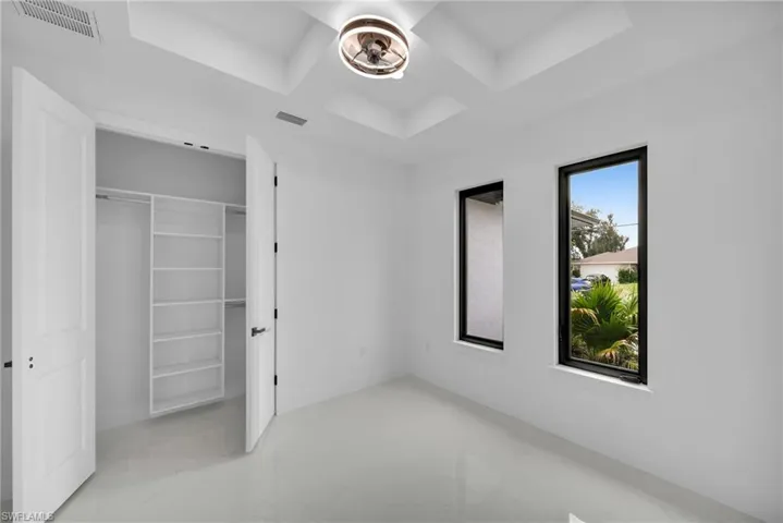 Unfurnished bedroom featuring a closet and coffered ceiling