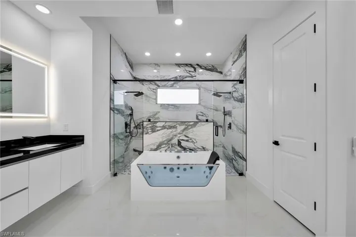 Bathroom with tile patterned flooring, plus walk in shower, and vanity