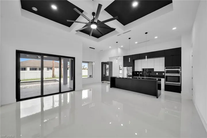 Kitchen featuring stainless steel appliances, hanging light fixtures, backsplash, light tile patterned flooring, and ceiling fan