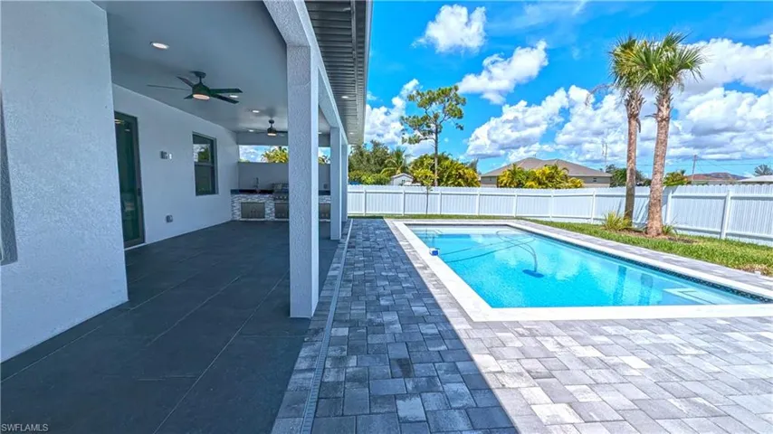 View of swimming pool featuring ceiling fan and a patio area