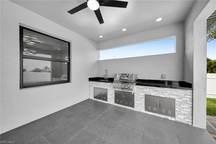 View of patio / terrace with area for grilling, exterior kitchen, sink, and ceiling fan