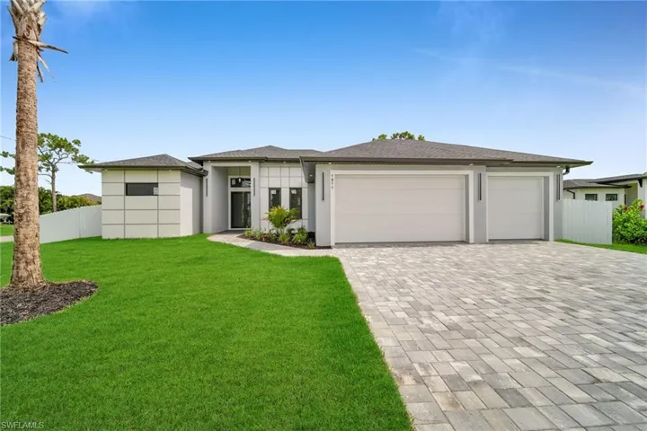 View of front facade featuring a garage and a front yard