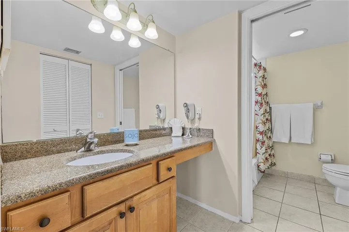 Full bathroom featuring tile patterned flooring, vanity, shower / bath combination with curtain, and toilet
