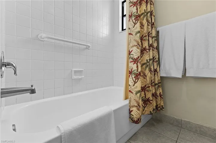 Bathroom with tile patterned floors and shower / bath combo