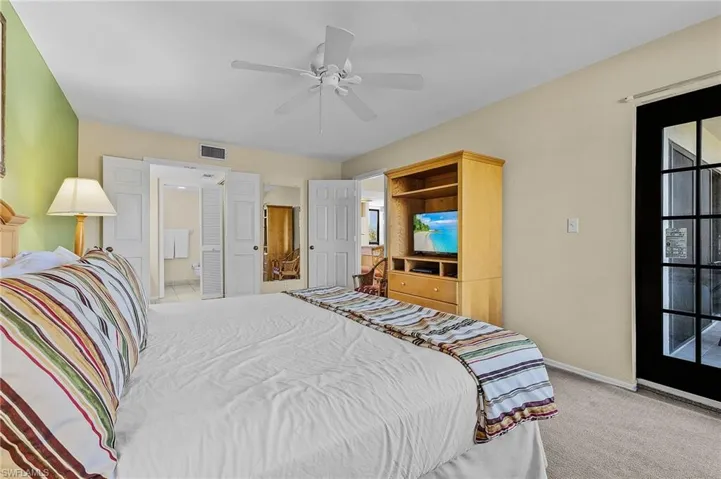 Carpeted bedroom featuring ceiling fan