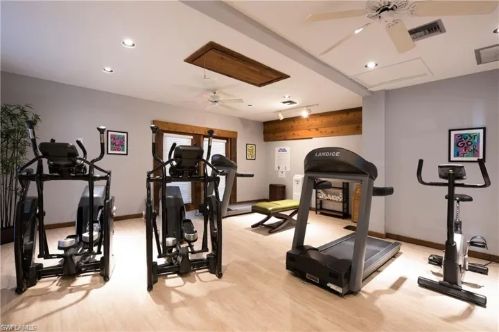 Exercise room featuring ceiling fan and light hardwood / wood-style flooring