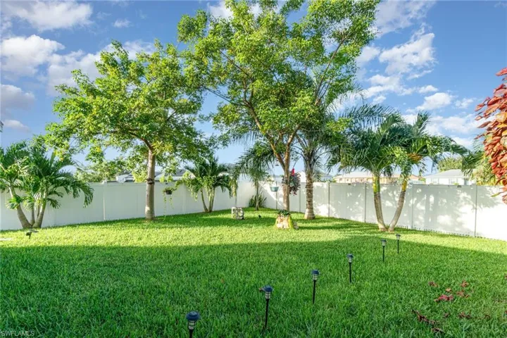 Fenced backyard with beautiful landscaping.